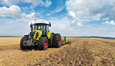 Zdjęcie ciągnika Claas ARION 400 z widocznym panoramicznym dachem i ładowaczem czołowym.