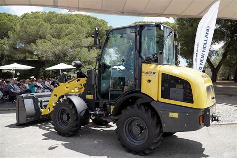 Ilustracja pokazująca pracę elektrycznej ładowarki New Holland W40X wewnątrz budynku