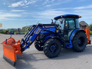 Grafika przedstawiająca ciągnik Yanmar z zamontowanym pługiem śnieżnym i ładowaczem czołowym.