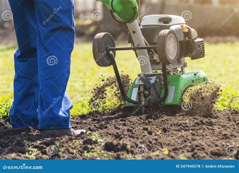 Thematic photo of a garden tiller in operation, preparing soil for planting