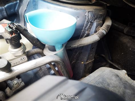 zdjęcie mechanika mierzącego ilość oleju spuszczonego ze sprężarki