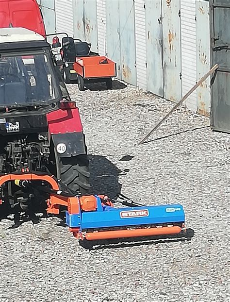 Zdjęcie kosiarki bijakowej tylno-bocznej w akcji na polu lub w sadzie