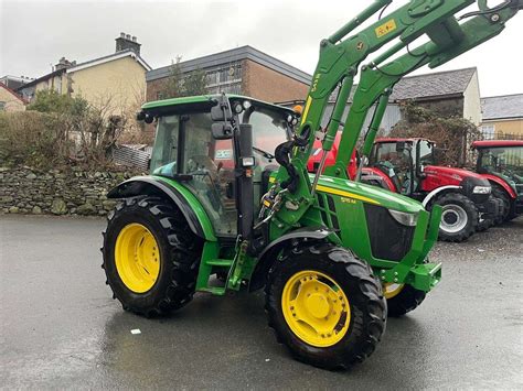 The John Deere 5115M tractor model with platform, showing its detailed design and functionalities.