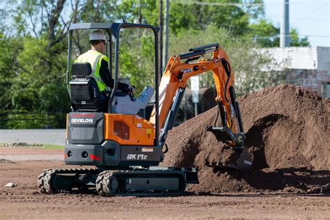 Thematic photo of a miniexcavator working in a confined garden space, showing its compact size and rubber tracks protecting the lawn.