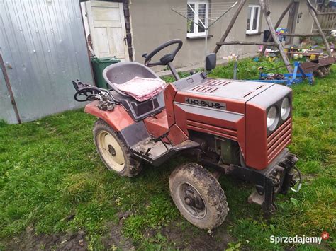 Rysunek techniczny lub zdjęcie mini ciągnika Urwis KMZ-012 z podpiętymi narzędziami