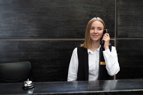 Uśmiechnięta, profesjonalna recepcjonistka witająca pacjenta w nowoczesnej klinice