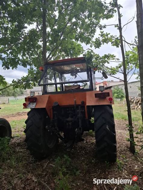Ciągnik rolniczy z turem i napędem 4x4 wykonujący prace porządkowe na placu