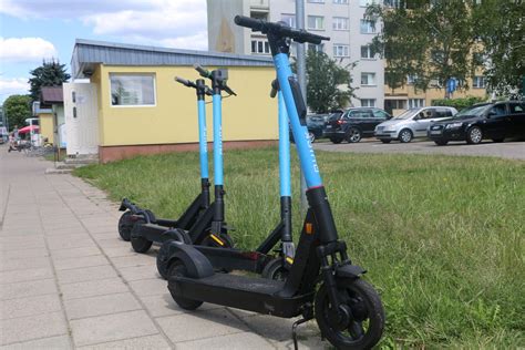 Tematyczne zdjęcie hulajnóg elektrycznych na ulicach miasta, gotowych do naładowania