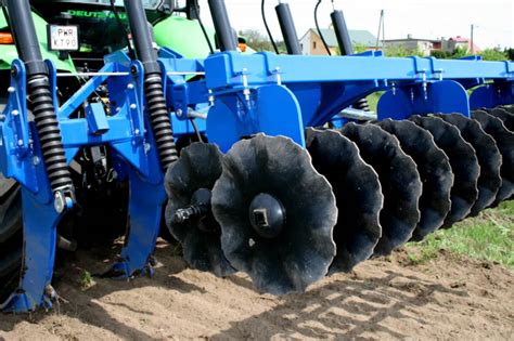 Przekrój bron talerzowych pokazujący układ talerzy, amortyzatorów i wału doprawiającego