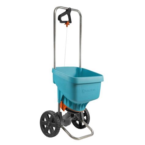Siewnik GARDENA z widocznym walcem dozującym i rozsiewanym materiałem