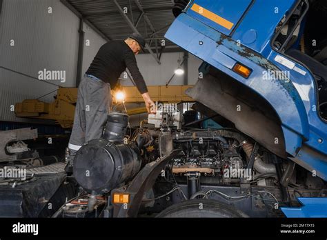 Photo of a tractor being serviced by a mechanic