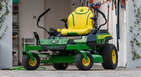 Photo of a John Deere lawn tractor with zero turn radius cutting grass around obstacles.