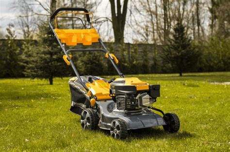 Thematyczne zdjęcie kosiarki spalinowej Powermat PM-KSS-6S w akcji na trawniku, z widocznym napędem i ergonomią uchwytu