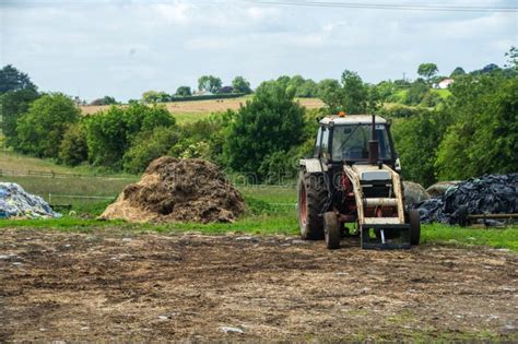 Thematic photo of a modern front loader on a tractor in a rural setting