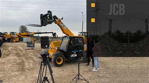 Zdjęcie przedstawiające technika serwisowego JCB przy pracy, z widocznym samochodem serwisowym Interhandler