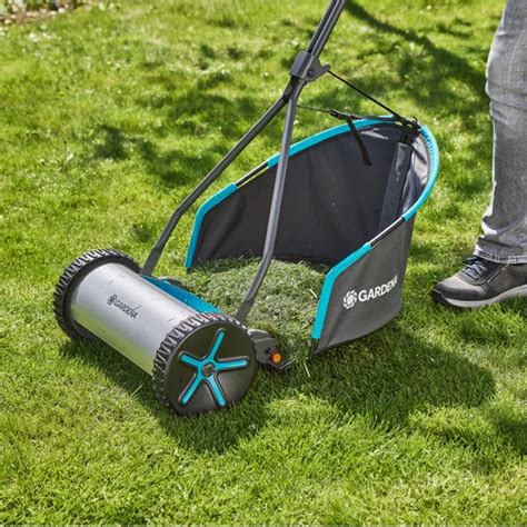 Zestawienie różnych modeli kosiarek bębnowych Gardena na tle zadbanego trawnika