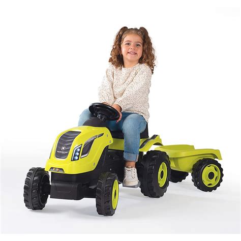 Dziecięcy traktor na pedały Smoby Farmer XL z przyczepą w zielonym kolorze, w plenerze.
