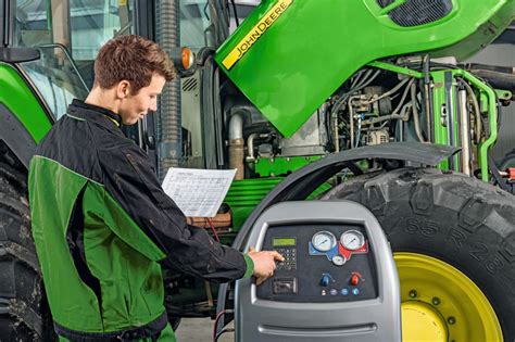 Zdjęcie mechanika serwisującego układ klimatyzacji w ciągniku