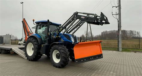 Ciągnik rolniczy z podniesionym osprzętem na podnośniku