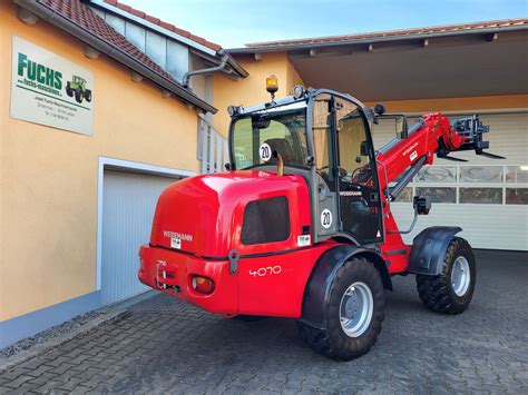 The Weidemann 4070 cx 100 wheel loader with a large bucket attached, suitable for handling various materials. The image should highlight the robust construction and cabin design.