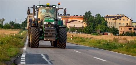Tematyczne zdjęcie nowoczesnego ciągnika rolniczego na drodze publicznej