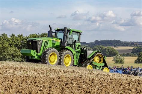 John Deere 9RX830 z gąsienicami na tle rozległego pola