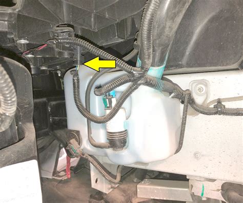 Technical diagram of a washer fluid reservoir with pump and nozzles