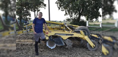 Rolnik operujący broną talerzową na polu podczas uprawy pożniwnej
