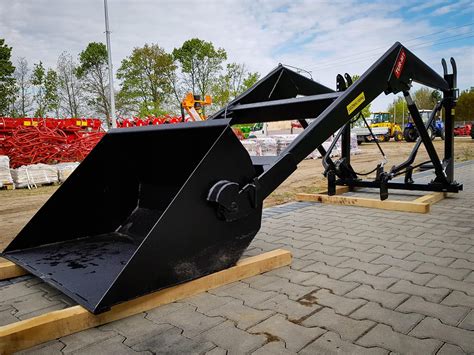 Ładowacz czołowy na ciągniku Ursus C-360 podczas pracy z belami słomy