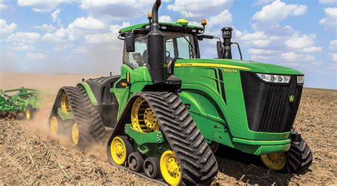 Zdjęcie trzech potężnych ciągników John Deere 9620RX pracujących na polu