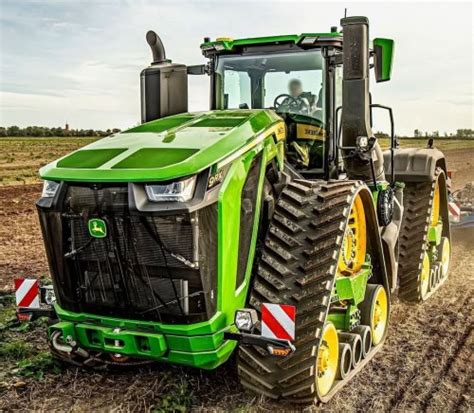 Zbliżenie na gąsienice ciągnika John Deere, podkreślające ich kontakt z podłożem