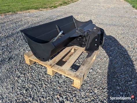 Różne rodzaje łyżek do koparko-ładowarek JCB, w tym łyżka skarpowa i kopiąca.