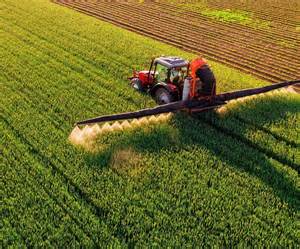 Traktor z opryskiwaczem na polu