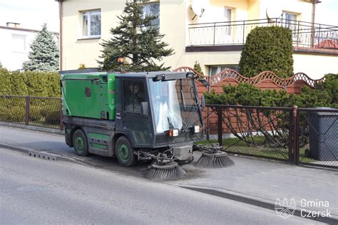 Zdjęcie przedstawiające zamiatarkę spalinową w akcji, zbierającą liście.