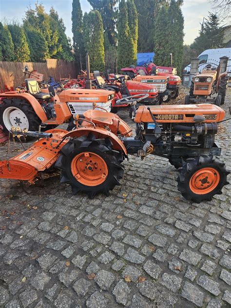 Mini traktorek pracujący w sadzie z zamontowaną glebogryzarką