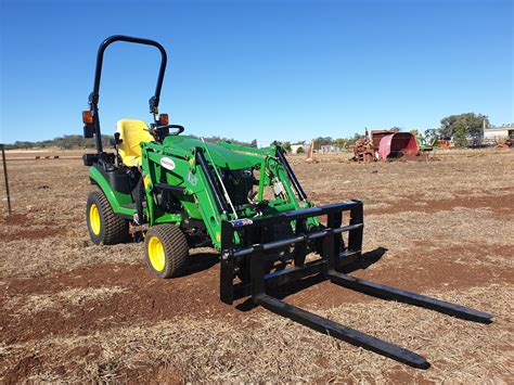 Thematic photo of a single-section front loader mounted on a tractor, performing farm work