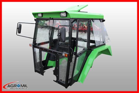 Grafika przedstawiająca wnętrze kabiny nowoczesnego ciągnika z ekranami i joystickami