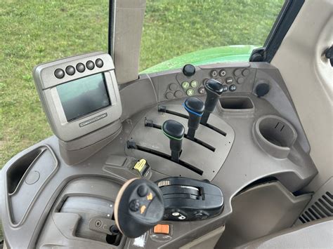 Wnętrze kabiny ciągnika John Deere 7530 z widokiem na panel sterowania i ergonomiczne siedzenie.