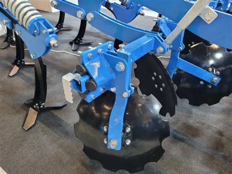 Zbliżenie na talerze wyrównujące kultywatora gruberek z widocznym amortyzatorem gumowym