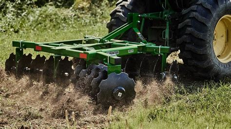 Thematic photo of a modern farm with a tractor and a disc harrow