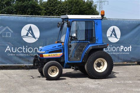Thematic photo of Iseki TU320 tractor working on a green area or small field