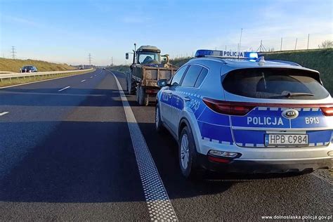 Policjanci prezentujący odzyskany ciągnik rolniczy po interwencji