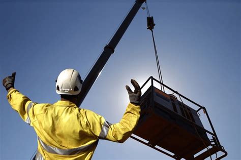 Thematic photo of a hooker-signaller communicating with a crane operator on a construction site