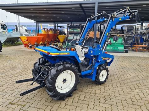 Traktor Iseki TU150 z przyczepą w lesie, transportujący drewno