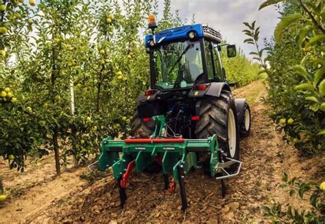 New Holland TN65N podczas pracy w sadzie