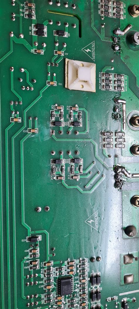 Zdjęcie uszkodzonej płytki PCB z widocznymi przepalonymi elementami