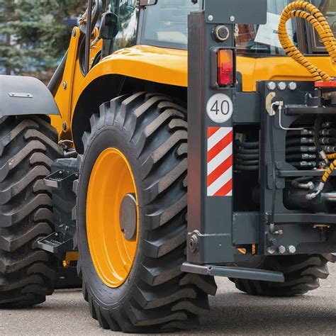 ilustracja przedstawiająca proces naklejania naklejki na maszynę rolniczą z widoczną folią transportową
