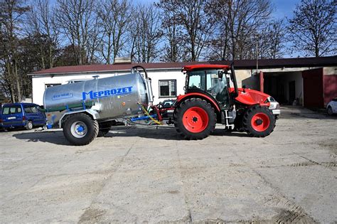 Zdjęcie pokazujące traktor z wozem asenizacyjnym i aplikatorem w pracy polowej