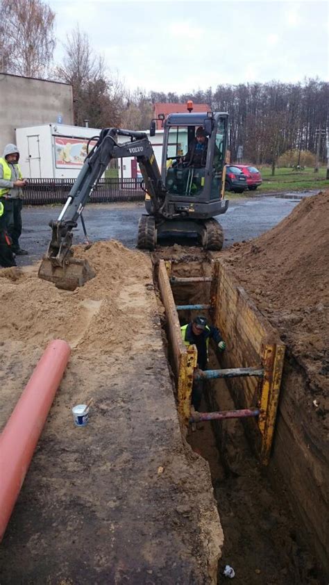 Koparka przeprowadzająca prace ziemne przy rozbiórce budynku