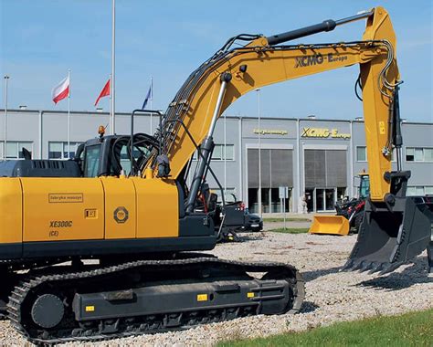 Klasyczna koparka gąsienicowa pracująca na dużym placu budowy.